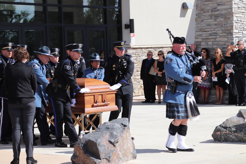 Piper Tim Lambert leads pallbearers and the casket for Brighton police Cmdr. Frank Acosta to the waiting hearse at his Sept. 29 funeral at Henderson's Orchard Church.